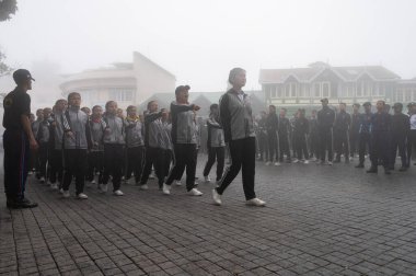 Darjeeling, Batı Bengal, Hindistan -11.08.2023: Bağımsızlık Günü hazırlığı 15 Ağustos 2023. Askeri eğitim için Darjeeling Alışveriş Merkezi 'nin önünden geçen öğrenciler. Sisli bir sabah.