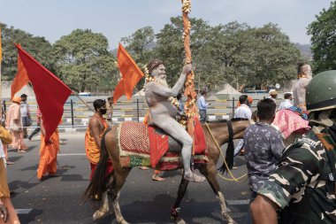 Haridwar, Uttarakhand, Hindistan - 16 Nisan 2021: Hindu çıplak sadhu, naga baba, naga sanyasi Ganj nehrinde shahi snaan yediği ve Har Har Mahadev diye bağırdığı için at sürüyor. Kumbhmela olayı.
