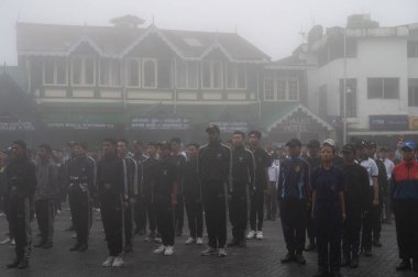 Darjeeling, Batı Bengal, Hindistan -11.08.2023: 15 Ağustos 2023 'te Bağımsızlık Günü kutlamaları için Darjeeling Alışveriş Merkezi' nde yürüyüş yapan öğrenciler, askeri eğitim. Sisli bir sabah.