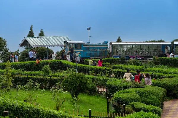 Darjeeling, Batı Bengal, Hindistan - 20.08.2023: Hint ordusunun savaş anıtı Batasia döngüsünden geçen Diesel Oyuncak treni. Darjeeling Himalaya Demiryolu, Unesco dünya mirası alanı, Himalaya musonu.
