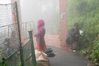 Darjeeling, Batı Bengal, Hindistan-11.08.2023: Mahakal Tapınağı veya Mahakal Mandir 'deki Hindu tapınağı, Shiva ve Lord Buddhha' ya adanmıştır. Muson sisiyle kaplı yemyeşil bir yol..