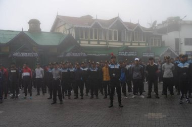 Darjeeling, Batı Bengal, Hindistan -11.08.2023: Bağımsızlık Günü hazırlığı 15 Ağustos 2023. Askeri eğitim için Darjeeling Alışveriş Merkezi 'nin önünden geçen öğrenciler. Sisli bir sabah.