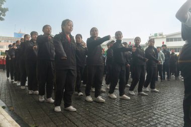 Darjeeling, Batı Bengal, Hindistan -11.08.2023: Sisli sabahlarda liseli kızlar için askeri eğitim, Bağımsızlık Günü kutlamaları için Darjeeling Alışveriş Merkezi 'nin önünden geçen öğrenciler.