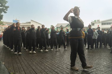 Darjeeling, Batı Bengal, Hindistan -11.08.2023: Sisli sabahlarda liseli kızlar için askeri eğitim, Bağımsızlık Günü kutlamaları için Darjeeling Alışveriş Merkezi 'nin önünden geçen öğrenciler.