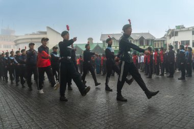 Darjeeling, Batı Bengal, Hindistan -11.08.2023: 15 Ağustos 2023 'te Bağımsızlık Günü kutlamaları için Darjeeling Alışveriş Merkezi' nde yürüyüş yapan öğrenciler, askeri eğitim. Sisli bir sabah.