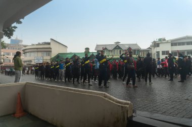 Darjeeling, Batı Bengal, Hindistan -11.08.2023: Bağımsızlık Günü hazırlığı 15 Ağustos 2023. Askeri eğitim için Darjeeling Alışveriş Merkezi 'nin önünden geçen öğrenciler. Sisli bir sabah.