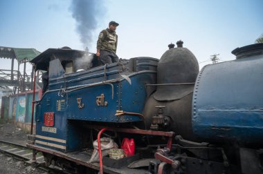 Darjeeling, Batı Bengal, Hindistan-20.08.2023: Oyuncak treninin Buhar makinesinden çıkan sıcak buhar, Motor Şoförü Himalayalar 'da, Ghum İstasyonu' nda yolculuğu kontrol ediyor. Unesco Dünya Mirası.