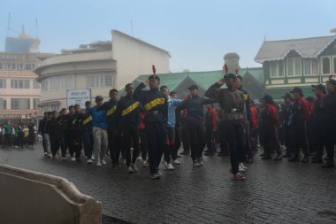 Darjeeling, Batı Bengal, Hindistan -11.08.2023: 15 Ağustos 2023 'te Bağımsızlık Günü kutlamaları için Darjeeling Alışveriş Merkezi' nde yürüyüş yapan öğrenciler, askeri eğitim. Sisli bir sabah.