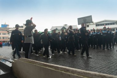 Darjeeling, Batı Bengal, Hindistan -11.08.2023: Sisli sabahlarda liseli kızlar için askeri eğitim, Bağımsızlık Günü kutlamaları için Darjeeling Alışveriş Merkezi 'nin önünden geçen öğrenciler.