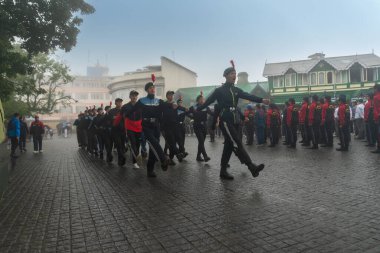 Darjeeling, Batı Bengal, Hindistan -11.08.2023: 15 Ağustos 2023 'te Bağımsızlık Günü kutlamaları için Darjeeling Alışveriş Merkezi' nde yürüyüş yapan öğrenciler, askeri eğitim. Sisli bir sabah.