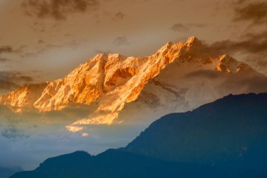 Kanchenjugha Dağı 'nda güneşin batışının dramatik son ışığı Himalaya sıradağları, Sikkim, Hindistan. Alacakaranlıkta dağların renkleri boyanacak. Himalaya sıradağlarını görmek için turizm beldesi.