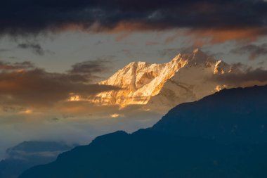 Kanchenjugha Dağı 'nda güneşin batışının dramatik son ışığı Himalaya sıradağları, Sikkim, Hindistan. Alacakaranlıkta dağların renkleri boyanacak. Himalaya sıradağlarını görmek için turizm beldesi.