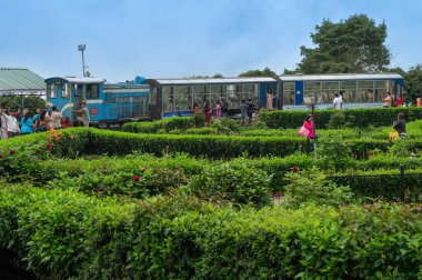 Darjeeling, Batı Bengal, Hindistan - 20.08.2023: Hint ordusunun savaş anıtı Batasia döngüsünden geçen Diesel Oyuncak treni. Darjeeling Himalaya Demiryolu, Unesco dünya mirası alanı, Himalaya musonu.