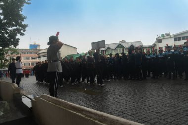 Darjeeling, Batı Bengal, Hindistan -11.08.2023: Sisli sabahlarda liseli kızlar için askeri eğitim, Bağımsızlık Günü kutlamaları için Darjeeling Alışveriş Merkezi 'nin önünden geçen öğrenciler.