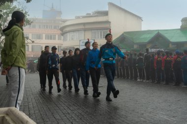 Darjeeling, Batı Bengal, Hindistan -11.08.2023: Bağımsızlık Günü hazırlığı 15 Ağustos 2023. Askeri eğitim için Darjeeling Alışveriş Merkezi 'nin önünden geçen öğrenciler. Sisli bir sabah.