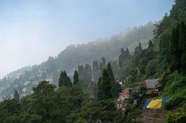 Hindistan, Batı Bengal, Darjeeling 'deki Himalaya dağlarının üzerinden geçen muson bulutları. Darjeeling 'e tepelerin kraliçesi denir ve yağmur mevsiminde güzel yeşil tepeleri olan manzaralı bir yerdir..