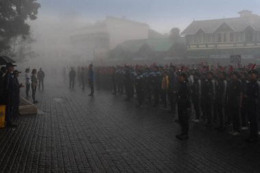 Darjeeling, Batı Bengal, Hindistan -11.08.2023: 15 Ağustos 2023 'te Bağımsızlık Günü kutlamaları için Darjeeling Alışveriş Merkezi' nde yürüyüş yapan öğrenciler, askeri eğitim. Sisli bir sabah.