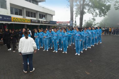 Darjeeling, Batı Bengal, Hindistan -11.08.2023: Sisli sabahta liseli kızlar askeri eğitim, Bağımsızlık Günü kutlamalarına hazırlanmak için Darjeeling Alışveriş Merkezi 'nde geçmişteki yürüyüşlere hazırlanan öğrenciler.