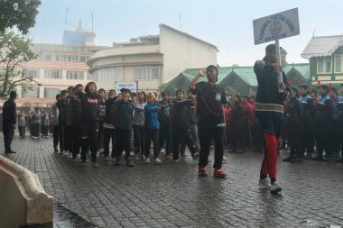 Darjeeling, Batı Bengal, Hindistan -11.08.2023: 15 Ağustos 2023 'te Bağımsızlık Günü kutlamaları için Darjeeling Alışveriş Merkezi' nde yürüyüş yapan öğrenciler, askeri eğitim. Sisli bir sabah.