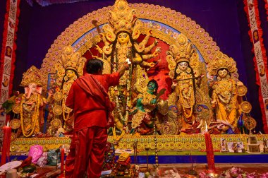 Howrah, Batı Bengal, Hindistan -11.10.2024: Hindu purohit tanrıça Durga 'ya tapma aydınlatma diya, pradip, kutsal lamba nabami puja sırasında. Geleneksel Durga puja ritüeli.