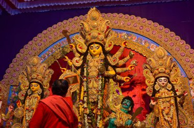 Howrah, Batı Bengal, Hindistan -11.10.2024: Hindu purohit tanrıça Durga 'ya tapma aydınlatma diya, pradip, kutsal lamba nabami puja sırasında. Geleneksel Durga puja ritüeli.