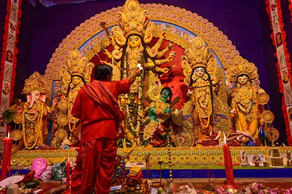 Howrah, Batı Bengal, Hindistan -11.10.2024: Hindu purohit tanrıça Durga 'ya tapma aydınlatma diya, pradip, kutsal lamba nabami puja sırasında. Geleneksel Durga puja ritüeli.