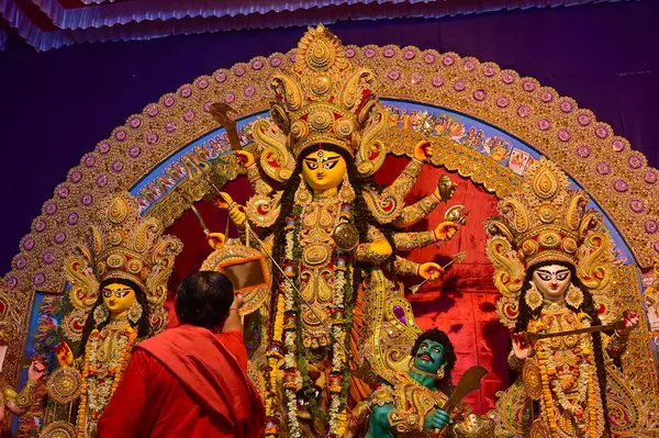 Howrah, Batı Bengal, Hindistan -11.10.2024: Hindu purohit tanrıça Durga 'ya tapma aydınlatma diya, pradip, kutsal lamba nabami puja sırasında. Geleneksel Durga puja ritüeli.