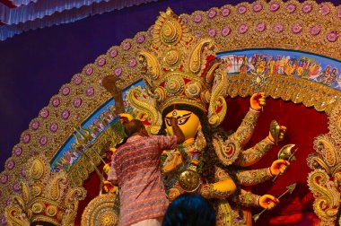 Howrah, Batı Bengal, Hindistan -11.10.2024: Hindu dindarlar Tanrıça Durga putunu puja için hazırlıyorlar. Geleneksel Durga puja ritüeli.