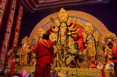 Howrah, Batı Bengal, Hindistan -11.10.2024: Hindu purohit tanrıça Durga 'ya tapma aydınlatma diya, pradip, kutsal lamba nabami puja sırasında. Geleneksel Durga puja ritüeli.