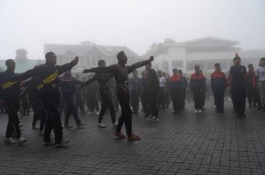 Darjeeling, Batı Bengal, Hindistan -11.08.2023: 15 Ağustos 2023 'te Bağımsızlık Günü kutlamaları için Darjeeling Alışveriş Merkezi' nde yürüyüş yapan öğrenciler, askeri eğitim. Sisli bir sabah.