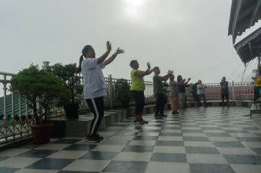 Darjeeling, Batı Bengal, Hindistan - 11.08.2023: Darjeeling alışveriş merkezinde sağlık bilincine sahip genç kadınların spor ve grup egzersizleri. Genç Himalaya yaşam tarzıyla spor kıyafetleriyle dans ediyor..