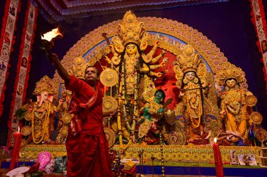 Howrah, Batı Bengal, Hindistan -11.10.2024: Hindu purohit tanrıça Durga 'ya tapma aydınlatma diya, pradip, kutsal lamba nabami puja sırasında. Geleneksel Durga puja ritüeli.