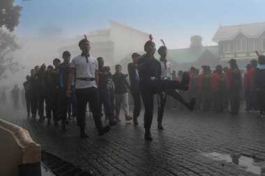 Darjeeling, Batı Bengal, Hindistan -11.08.2023: 15 Ağustos 2023 'te Bağımsızlık Günü kutlamaları için Darjeeling Alışveriş Merkezi' nde yürüyüş yapan öğrenciler, askeri eğitim. Sisli bir sabah.