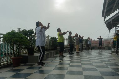 Darjeeling, Batı Bengal, Hindistan - 11.08.2023: Darjeeling alışveriş merkezinde sağlık bilincine sahip genç kadınların spor ve grup egzersizleri. Genç Himalaya yaşam tarzıyla spor kıyafetleriyle dans ediyor..