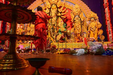 Howrah, Batı Bengal, Hindistan -11.10.2024: Hindu purohit tanrıça Durga 'ya tapma aydınlatma diya, pradip, kutsal lamba nabami puja sırasında. Geleneksel Durga puja ritüeli.