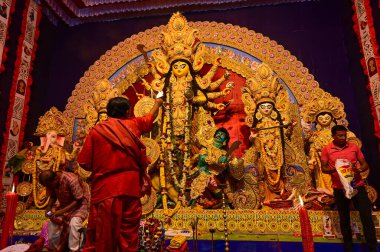 Howrah, Batı Bengal, Hindistan -11.10.2024: Hindu purohit tanrıça Durga 'ya tapma aydınlatma diya, pradip, kutsal lamba nabami puja sırasında. Geleneksel Durga puja ritüeli.