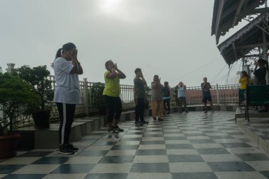 Darjeeling, Batı Bengal, Hindistan - 11.08.2023: Spor yapan genç kadınlar, Darjeeling alışveriş merkezinde sisli bir sabah geçirerek, sağlık bilincine sahip kadınların grup egzersizlerinin faydalarını gösteriyorlar. Genç Himalaya yaşam tarzı.