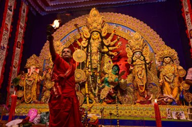 Howrah, Batı Bengal, Hindistan -11.10.2024: Hindu purohit tanrıça Durga 'ya tapma aydınlatma diya, pradip, kutsal lamba nabami puja sırasında. Geleneksel Durga puja ritüeli.