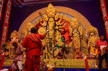 Howrah, Batı Bengal, Hindistan -11.10.2024: Hindu purohit tanrıça Durga 'ya tapma aydınlatma diya, pradip, kutsal lamba nabami puja sırasında. Geleneksel Durga puja ritüeli.