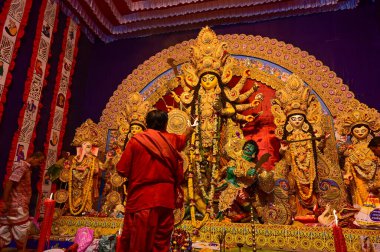 Howrah, Batı Bengal, Hindistan -11.10.2024: Hindu purohit tanrıça Durga 'ya tapma aydınlatma diya, pradip, kutsal lamba nabami puja sırasında. Geleneksel Durga puja ritüeli.