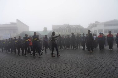 Darjeeling, Batı Bengal, Hindistan -11.08.2023: 15 Ağustos 2023 'te Bağımsızlık Günü kutlamaları için Darjeeling Alışveriş Merkezi' nde yürüyüş yapan öğrenciler, askeri eğitim. Sisli bir sabah.