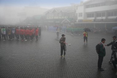 Darjeeling, Batı Bengal, Hindistan -11.08.2023: 15 Ağustos 2023 'te Bağımsızlık Günü kutlamaları için Darjeeling Alışveriş Merkezi' nde yürüyüş yapan öğrenciler, askeri eğitim. Sisli bir sabah.