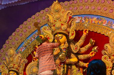 Howrah, Batı Bengal, Hindistan -11.10.2024: Hindu dindarlar Tanrıça Durga putunu puja için hazırlıyorlar. Geleneksel Durga puja ritüeli.
