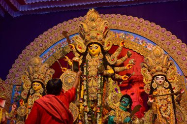 Howrah, Batı Bengal, Hindistan -11.10.2024: Hindu purohit tanrıça Durga 'ya tapma aydınlatma diya, pradip, kutsal lamba nabami puja sırasında. Geleneksel Durga puja ritüeli.