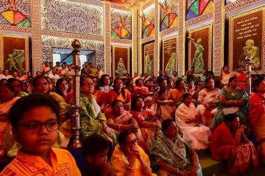 Howrah, Batı Bengal, Hindistan -11.10.2024: Hintli kadınlar Tanrıça Durga 'ya tapınıyor ve oturuyorlar, sondhipujo sırasında, puja Ashtami ve nabami arasında. Geleneksel Bengali puja ritüeli.
