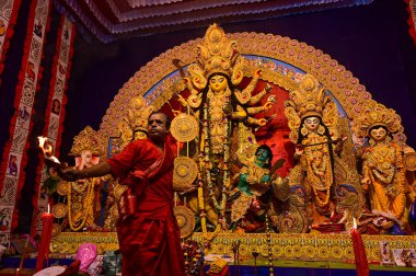 Howrah, Batı Bengal, Hindistan -11.10.2024: Hindu purohit tanrıça Durga 'ya tapma aydınlatma diya, pradip, kutsal lamba nabami puja sırasında. Geleneksel Durga puja ritüeli.