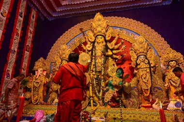 Howrah, Batı Bengal, Hindistan -11.10.2024: Hindu purohit tanrıça Durga 'ya tapma aydınlatma diya, pradip, kutsal lamba nabami puja sırasında. Geleneksel Durga puja ritüeli.