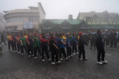 Darjeeling, Batı Bengal, Hindistan-11.08.2023: Sisli sabahlarda kız askeri eğitim. 15 Ağustos 'ta Bağımsızlık Günü kutlamalarına hazırlanmak üzere Darjeeling Alışveriş Merkezi' nde geçen okul öğrencileri.