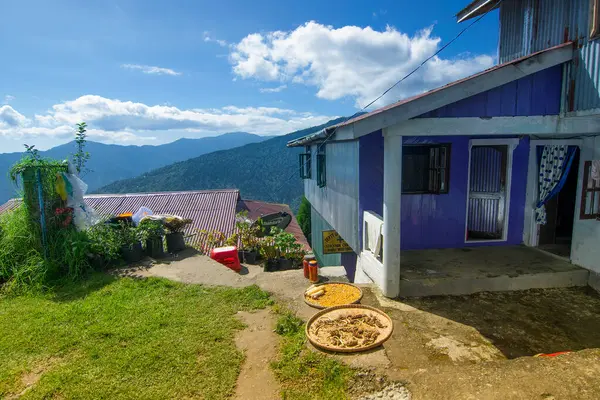 Arka planda Himalaya Dağları 'ndaki Okhrey Köyü' nde bir ev var. Okhrey, Sikkim, Hindistan 'da manzaralı doğal manzarası olan uzak bir köydür. Her yerden gelen turistler için birçok ev konaklama yeri mevcut..