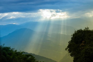 Rabangla, Sikkim, Hindistan 'dan gelen güneş ışınları. Ön planda Slihoutte ağaçları ve arka planda Himalaya dağları. Sikkim 'li Büyük Himalayalar' ın muhteşem manzarası..